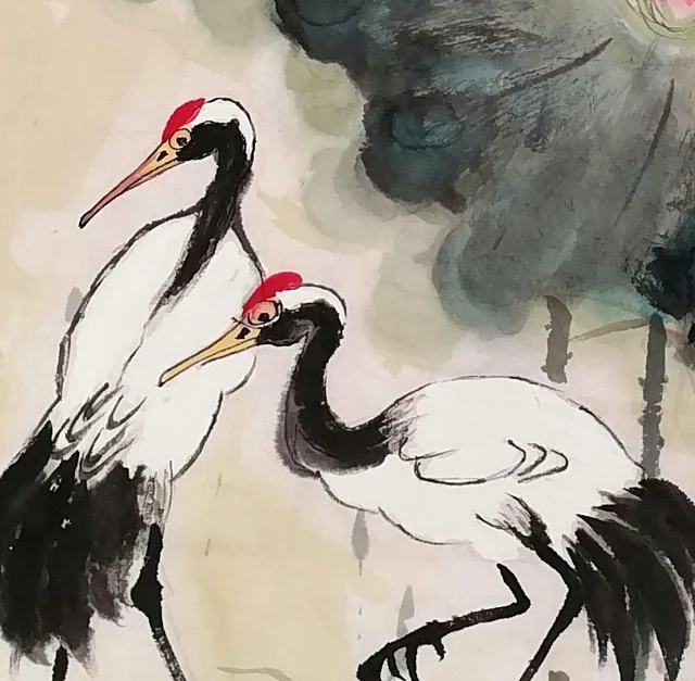 The pair of red-crowned cranes, each with its spot of red.