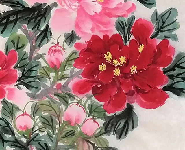 Deep red peonies and buds beneath the rock.
