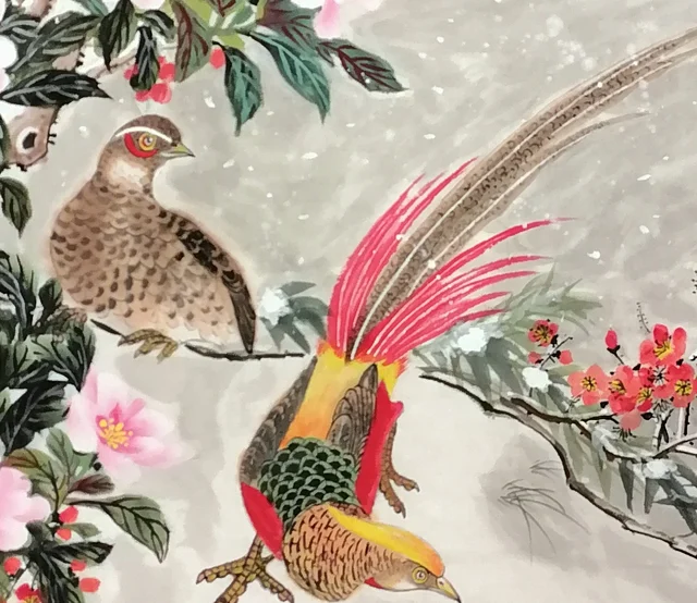The pair of golden pheasants on the snowy slope.
