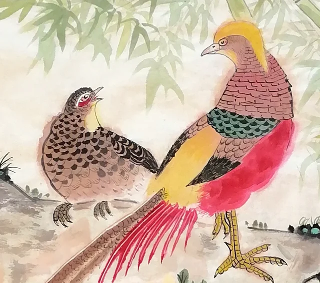 The pair of golden pheasants on the rock.