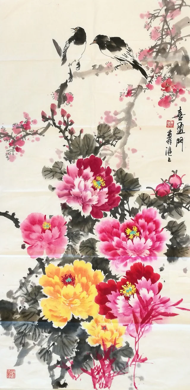 A tall painting of two magpies on a red-flowering plum branch at the top, and peonies in purple-red, crimson and gold below; calligraphy at the right.