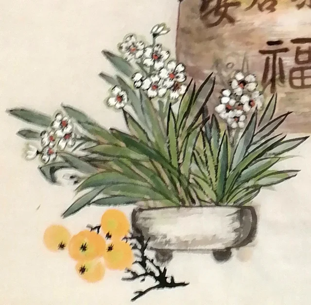 Narcissus in a shallow dish and orange fruits.