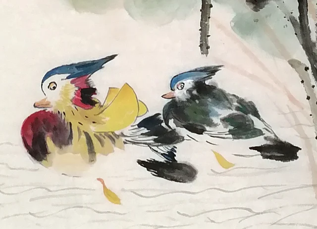 The pair of mandarin ducks, one following the other.