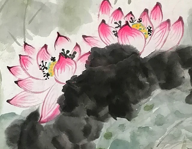 Two pink lotuses above the dark ink leaf.