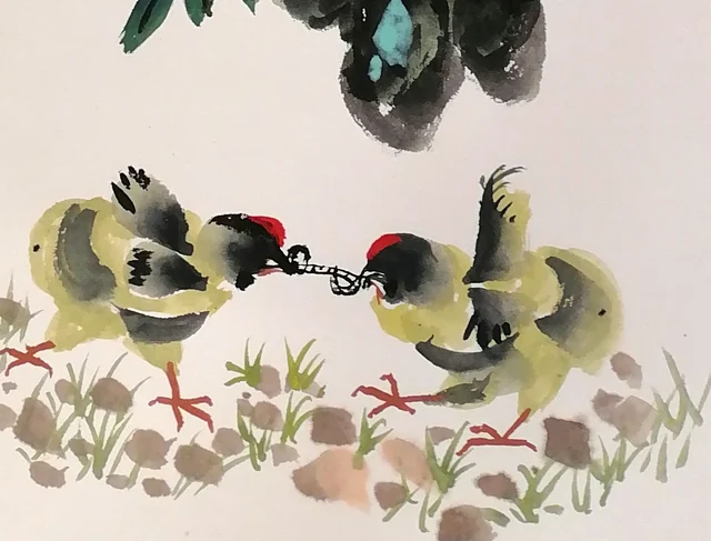Two chicks tugging at the same worm.