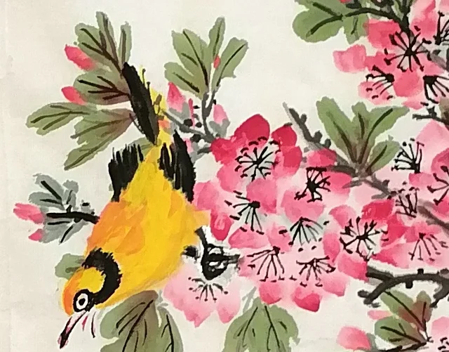 An oriole hanging head-down from its twig.