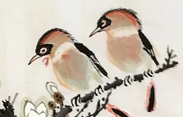 The pair of small birds on a twig.
