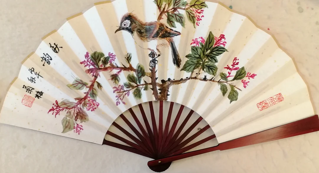 A folding fan painted with a stem of small red and purple flowers and a brown bird perched at the top, with calligraphy at the left.