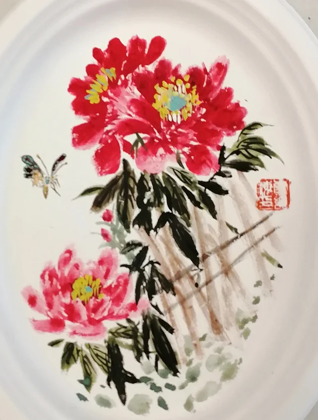 Two peonies before a light fence.