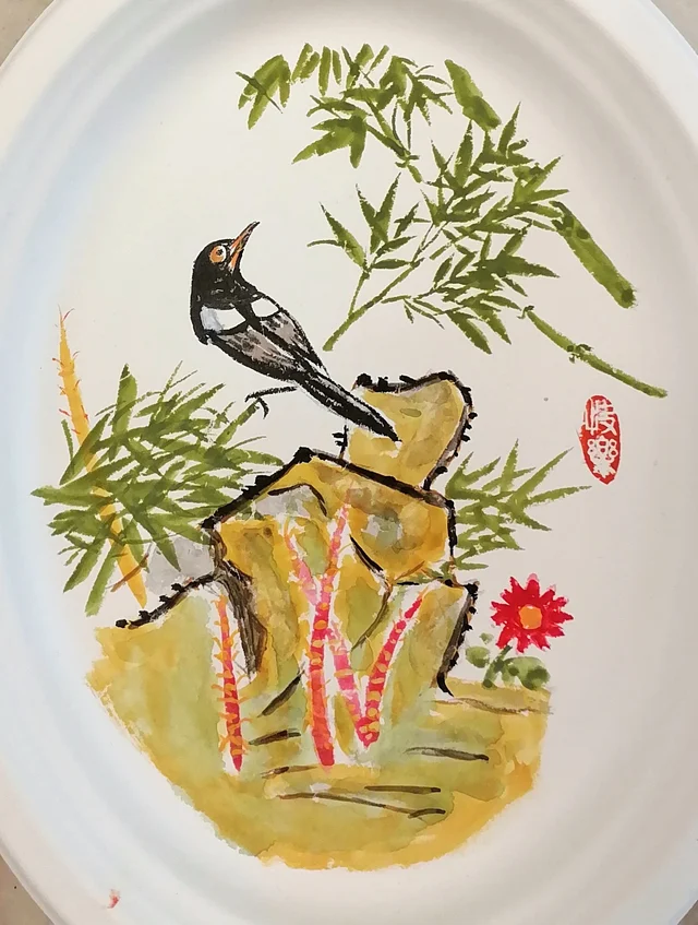 The magpie on the rock beside the bamboo.