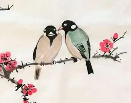 Two small birds side by side on the plum branch.