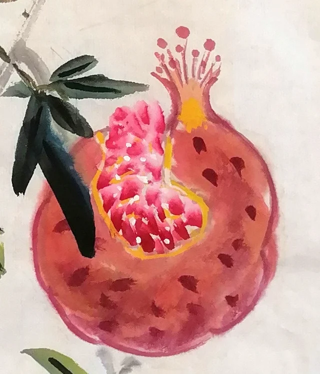 The pomegranate at the lower right, burst open.