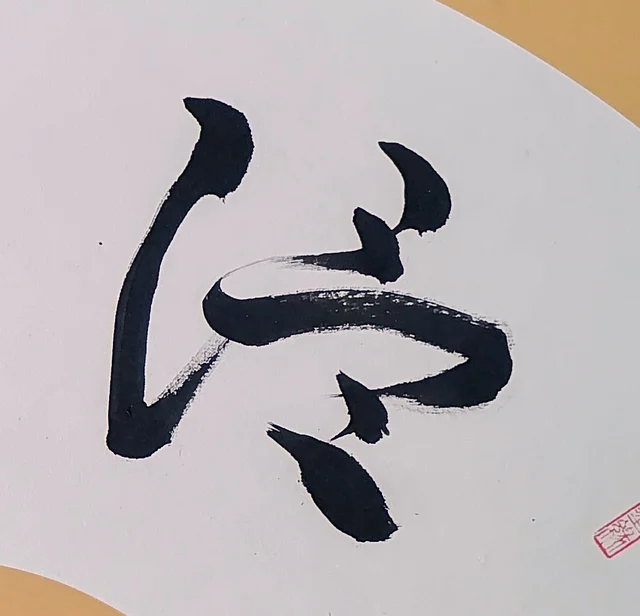 The right-hand character, its long vertical bent like a bow.