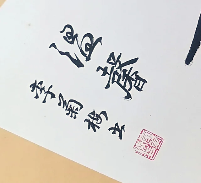 A line of small characters, the signature and a square seal.