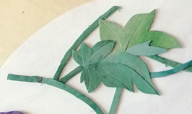 The vine, rolled strips of green cloth twisting and coiling.