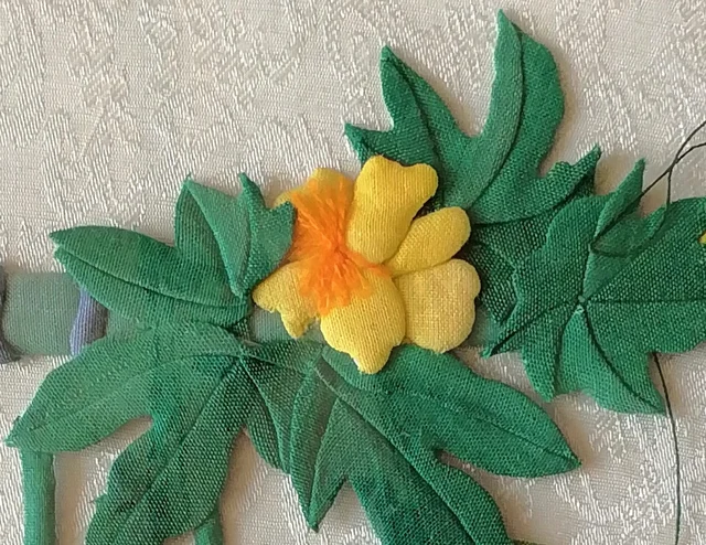 A yellow flower with an orange thread heart among the leaves.