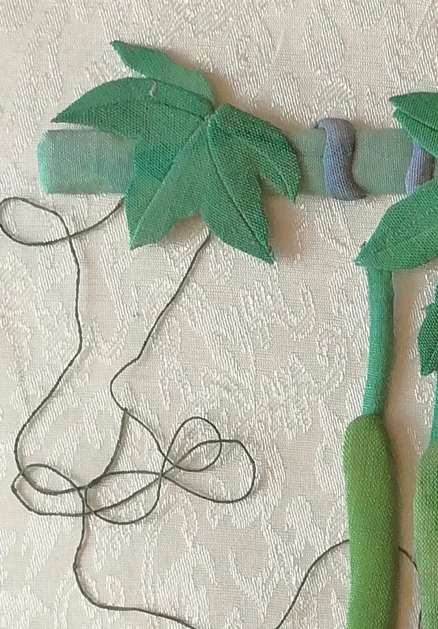 The trellis bar and loose tendrils of thread.