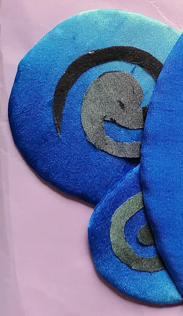 Blue disks with spirals of black and gray cloth.